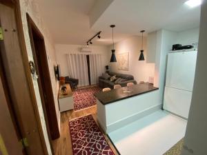 a kitchen and a living room with a refrigerator at Apartamento Campos do Jordao Home Green Home in Campos do Jordão