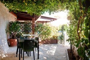 - une table et des chaises dans une terrasse arborée dans l'établissement Trullo Mimmo, à Locorotondo