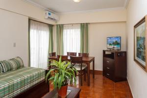 Una sala de estar con un sofá y una mesa de comedor. en Terrazas Playa, en Villa Gesell