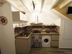 a kitchen with a sink and a washing machine at Casa Liò in Santa Flavia +24 photos