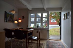 a dining room with a table and chairs and a window at Cosy house in the heart of Tórshavn (Á Reyni) in Tórshavn