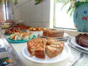 um buffet de diferentes tipos de bolos e produtos de pastelaria em Pousada Sunrise Beach em Cumbuco