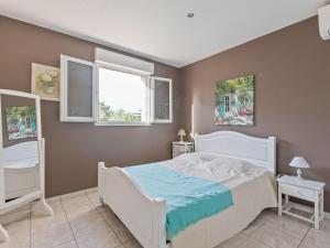 1 dormitorio con 1 cama blanca y 2 ventanas en House in the south of France with private pool en Roquebrun