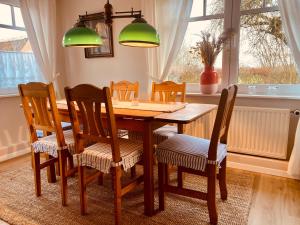 uma mesa de jantar com 4 cadeiras e uma janela em Hof Goosend - Urlaub an der Ostsee & Schlei em Gelting