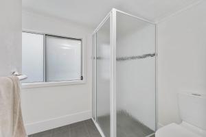 eine Glasdusche im Bad mit Fenster in der Unterkunft Frangipani Cottage in North Haven + 13 Fotos