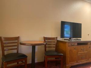 a room with a table and two chairs and a television at Oceano Inn in Oceano