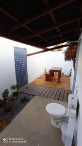 a bathroom with a toilet and a table on a deck at Pousada Eureka in Atins