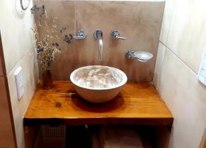 a bathroom with a bowl sink on a wooden table at Cabañas Las Moras in Tandil