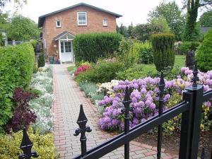 a garden with purple and white flowers and a house at One-Bedroom Apartment in Putbus I in Putbus
