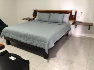 a bedroom with a large bed with blue pillows at Hotel "Casa Las Lolas" in Xpujil