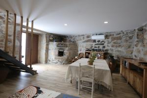 a dining room with a table and stone walls at Quinta de Bouças in Cabeceiras de Basto