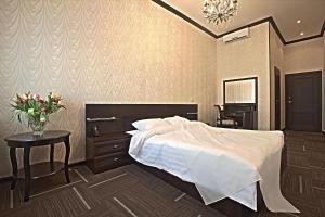 a bedroom with a bed and a table with a vase of flowers at D-Hotel Tverskaya in Moscow