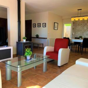 a living room with a red chair and a tv at Villa Manzanera in Calpe
