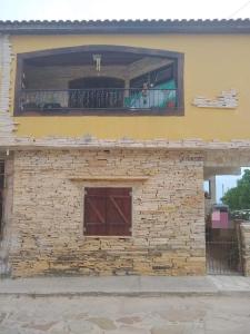 a brick building with a window and a balcony at Suites Mandala in São Thomé das Letras +10 photos