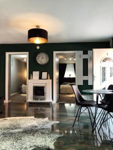 een woonkamer met groene muren en een tafel en stoelen bij VERACI Apartments in Sibiu