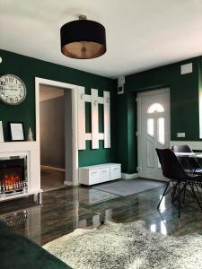 錫比烏的住宿－VERACI Apartments，客厅设有绿色的墙壁和壁炉