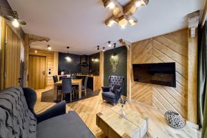 a living room with a table and a dining room at Aparthotel Giewont in Zakopane