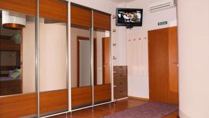a dressing room with mirrors and a tv on a wall at City Hostel Panorama in Uzhhorod