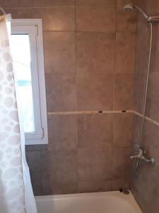 Un baño con ducha y bañera. en El Comienzo, en San Martín de los Andes