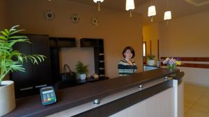 a woman standing at a counter in a lobby at City Hostel Panorama in Uzhhorod