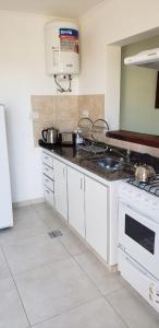 a kitchen with white cabinets and a stove top oven at Jenaz in Federación