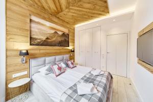 - une chambre avec un grand lit et une télévision dans l'établissement Aparthotel Giewont, à Zakopane