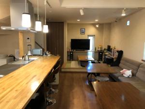Art Inn 24 Sapporo في Ōdōri: غرفة معيشة كبيرة مع أريكة وطاولة