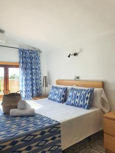 a bedroom with a bed with blue and white pillows at Eco Finca Sa Font Blava in Llucmajor