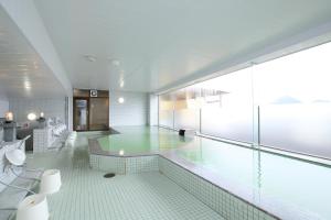 a large bathroom with a tub and a large window at Toya-onsen Hotel Hanabi in Lake Toya +40 photos