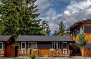 una casa con porche y valla en Piccadilly Motel, en Radium Hot Springs