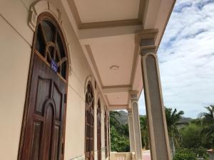 um edifício com uma porta com vista para o oceano em Hai Nam Guesthouse em Long Hai