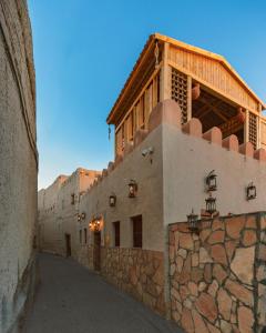 an alley with a building on top of a wall at Bait Al Aqr in Nizwa