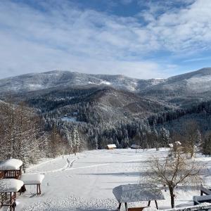 ein schneebedeckter Hügel mit Bänken und ein Berg in der Unterkunft Romanka in Żabnica