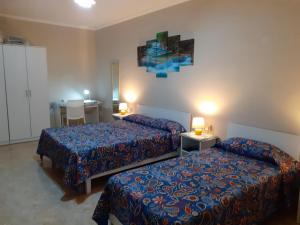 a hotel room with two beds and a table and a desk at Black Gold Private Room in Msida