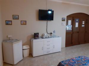 uma sala de estar com televisão na parede em Black Gold Private Room em Msida