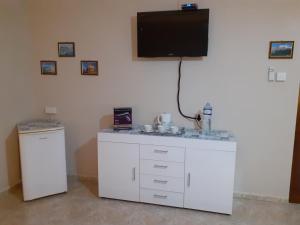 a room with a sink and a tv on the wall at Black Gold Private Room in Msida