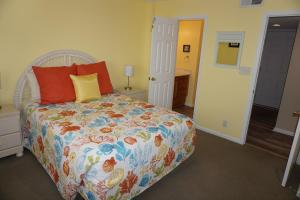 a bedroom with a bed with a colorful comforter at Shores of Surfside I - 205 home in Myrtle Beach
