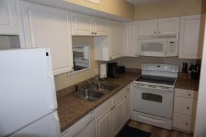 a kitchen with white cabinets and a sink at Shores of Surfside I - 205 home in Myrtle Beach