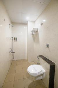 a bathroom with a shower and a toilet and a sink at Hotel Laxmi Cityside in Mangalore