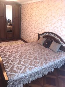Schlafzimmer mit einem Bett und einem Spiegel in der Unterkunft Однокомнатная квартира. Жилгородок in Atyrau