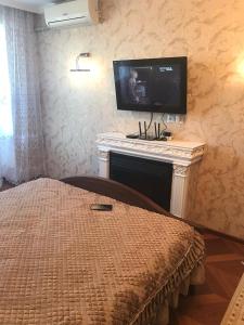 ein Schlafzimmer mit einem Kamin und einem TV über einem Kamin in der Unterkunft Однокомнатная квартира. Жилгородок in Atyrau