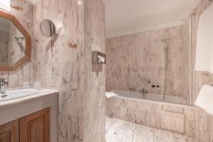 Un baño con bañera, lavabo y bañera. en Hotel Manos Stephanie, en Bruselas