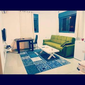 een woonkamer met een groene bank en een tafel bij family2 in Nahariyya