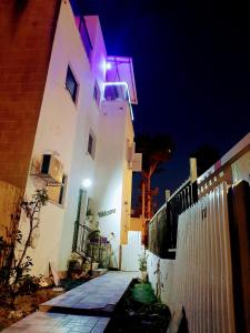 um edifício branco com uma luz roxa sobre ele em family2 em Nahariya