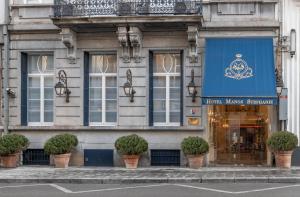 a store with a blue sign on the front of a building at Hotel Manos Stephanie in Brussels
