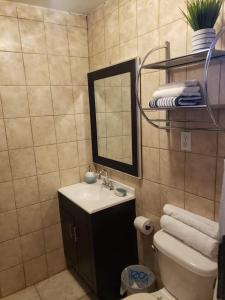 La salle de bains est pourvue d'un lavabo, d'un miroir et de toilettes. dans l'établissement The White Bungalow, à Rosarito