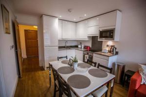 a kitchen with a table and chairs in a kitchen at *ALBAN COURT *COMFY SUITE * in Hatfield