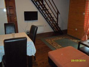 Habitación con mesa, sillas y escalera. en Apartments Sara, en Žabljak