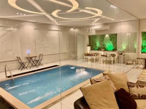 a large swimming pool in a living room with a couch at شالية فاخر بمسبح خاص بمكة المكرمة in Makkah