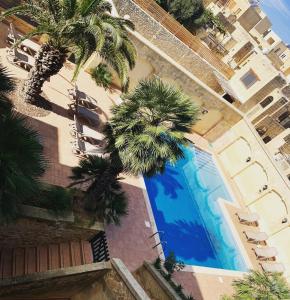 - une vue sur la piscine bordée de palmiers dans l'établissement Tal-Mirakli, à L-Għarb